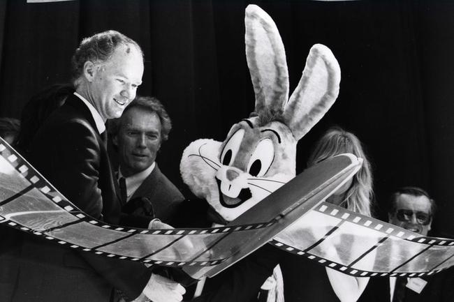 file pic 1991 Premier Wayne Goss cuts the film at the opening of Movie World - actor Clint Eastwood (C) actress Goldie Hawn hidden by scissors, bugs bunny character - profile theme parks Picture: Supplied