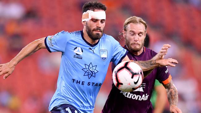 Sydney FC’s Anthony Caceres gets past Brisbane Roar’s Jacob Pepper on Friday night. Picture: AAP 