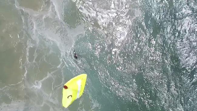 A yellow flotation device is dropped from a flying drone toward two teenagers caught in a rip-tide in heavy seas off the Lennox Beach. Pic: The Westpac Little Ripper.