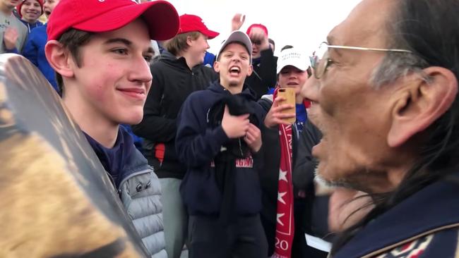 Covington Catholic High school students face a Native American elder.