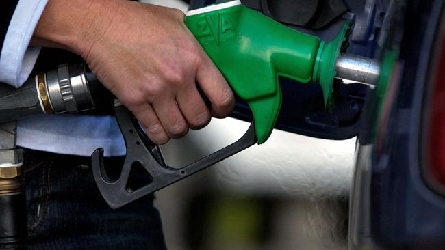 A motorist fills up at a service station in Sydney, Jul 04, 2005. picJack/Atley /Bloomberg /News bowser pump petrol fuel generic hand