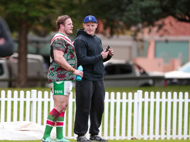 George Burgess and brother Tom Burgess watch on from the fence after hanging up a video call with brother Sam Burgess. Picture: Adam Wrightson Photography