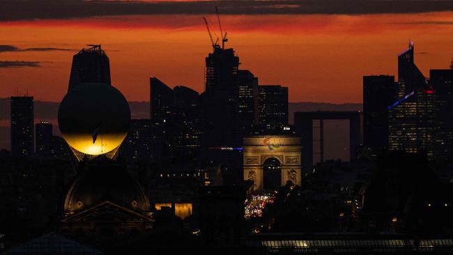 The Paris 2024 Olympic and Paralympic Games cauldron attached to a balloon carrying the Olympic and Paralympic flame, with the Arc de Triomphe and La Defense in the background. Picture: Joel Saget / AFP