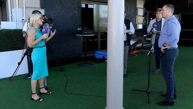 Trainer Tony Gollan (right) speaks to the media while observing social-distancing protocols after jockey Baylee Nothdurft rode Get Stuck In to victory in race 5, the Open Handicap, during Saturday Raceday at Eagle Farm Racecourse in Brisbane, Saturday, March 21, 2020. (AAP Image/Albert Perez) NO ARCHIVING, EDITORIAL USE ONLY