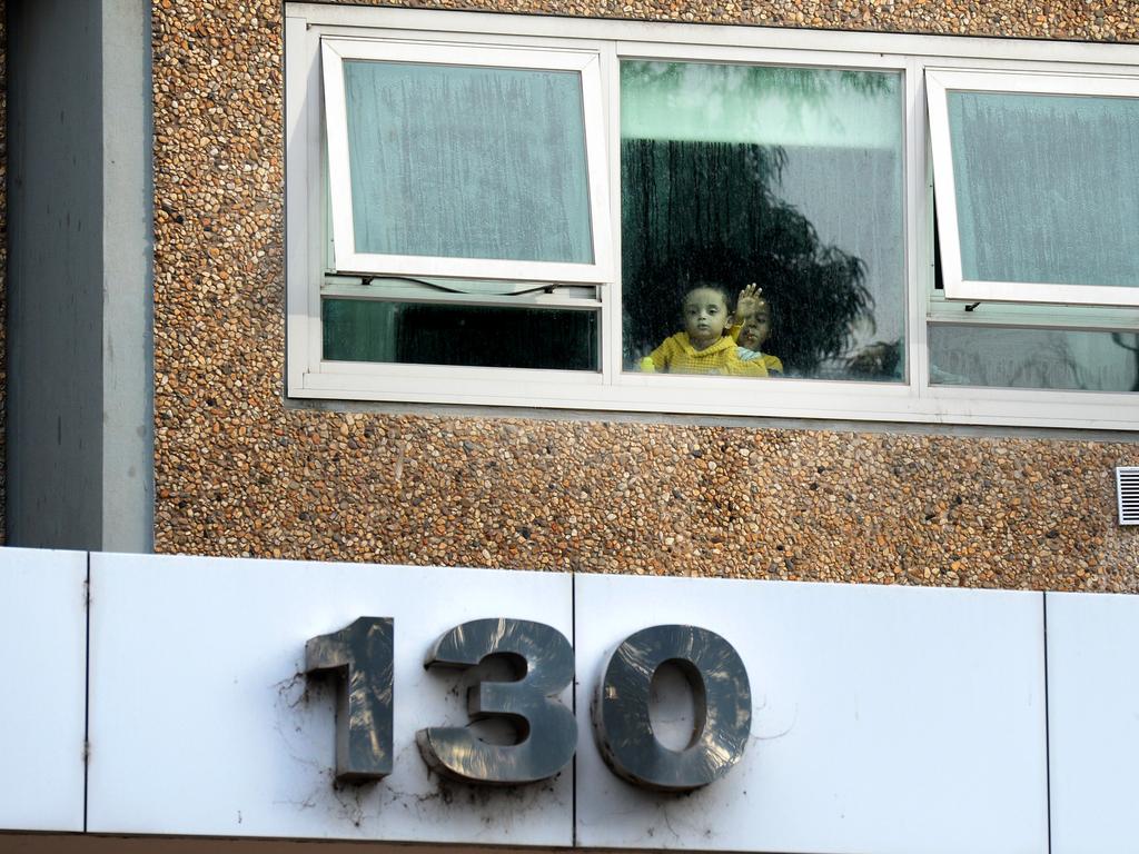 Residents look out from their window at the public housing tower at 130 Racecourse Rd Flemington. Picture: Andrew Henshaw