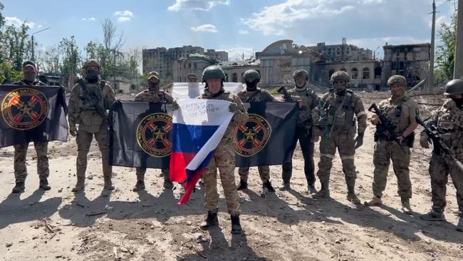 Wagner chief Yevgeny Prigozhin holds a Russian national flag in front of his soldiers holding Wagner Group's flags in Bakhmut. Picture: AFP