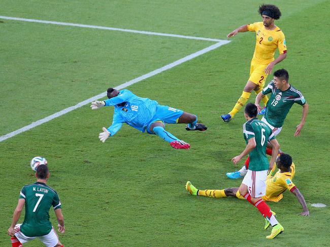 Oribe Peralta of Mexico shoots and scores a goal past goalkeeper Charles Itandje of Cameroon in the second half.