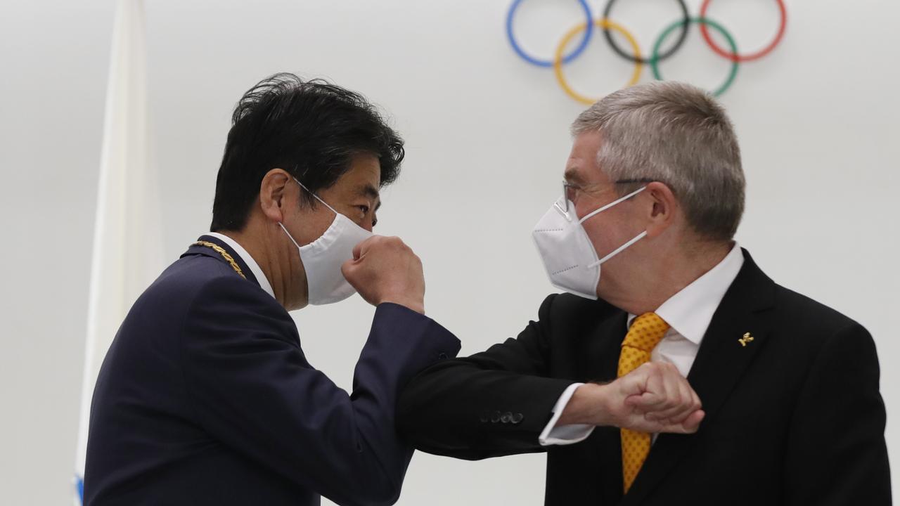 Japan's former Prime Minister Shinzo Abe and Thomas Bach, President of the International Olympic Committee (IOC), elbow bump. Photo: Getty Images