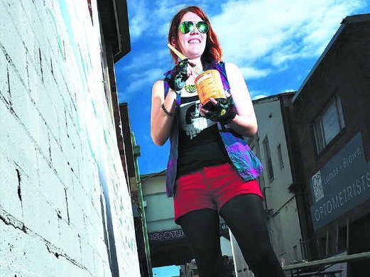 WALL TRANSFORMED: Solo artist Kate Hallen, of Lismore, gets stuck into the live street art revamping of Larkin Lane. Picture: Marc Stapelberg