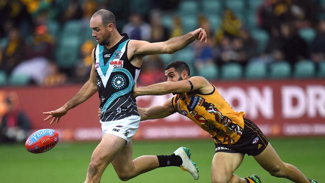 Matthew Broadbent of the Power gets a kick away ahead of Hawthorn’s Paul Puopolo. Picture: AAP Image/Julian Smith