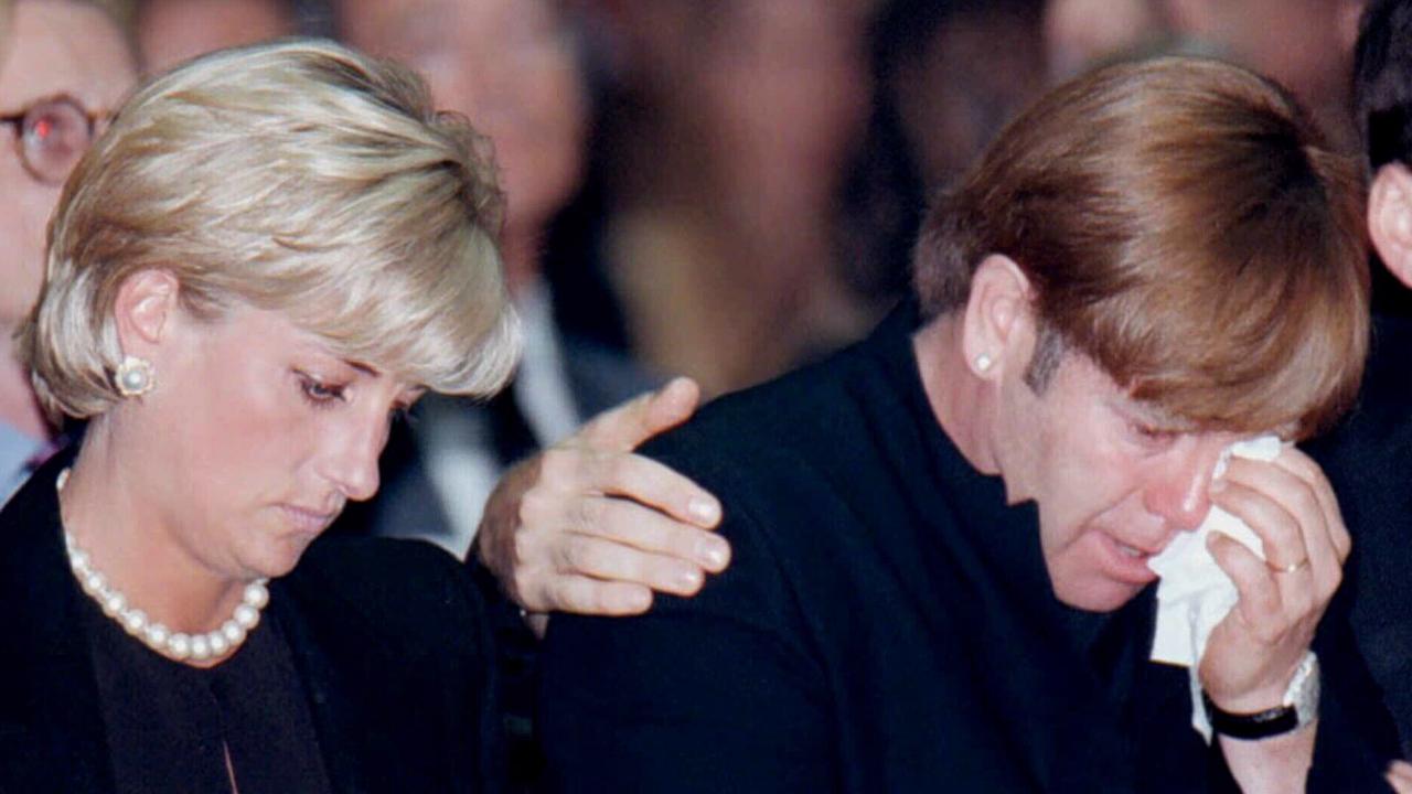 Diana next to Elton John at memorial mass in Milan's Roman Catholic Cathedral for designer Gianni Versace.