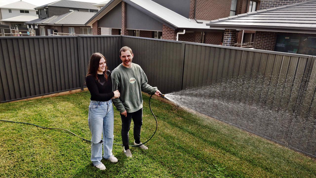 Tristan Tipler and his partner Stevie-Lyn Ritchie pictured watering the grass in their small backyard at Marsden Park. Picture: Sam Ruttyn