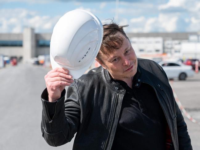 (FILES) In this file photo taken on May 17, 2021 Tesla CEO Elon Musk poses for a photo with a hard hat at the construction site for the new plant, the so-called "Giga Factory", of US electric carmaker Tesla in Gruenheide near Berlin, northeastern Germany. - US electric car pioneer Tesla received the go-ahead for its "gigafactory" in Germany on March 4, 2022, paving the way for production to begin shortly after an approval process dogged by delays and setbacks. (Photo by Christophe Gateau / dpa / AFP) / Germany OUT