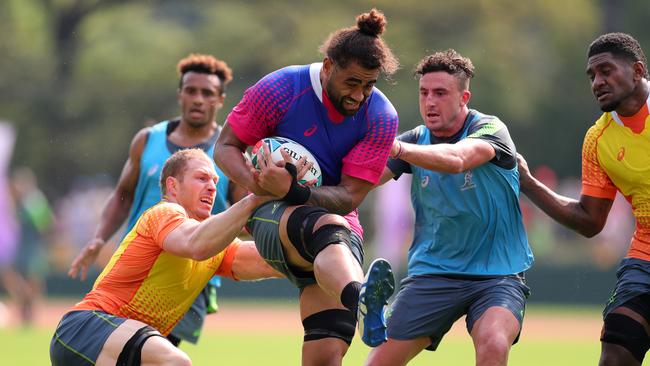 Lukham Salakaia-Loto of Australia takes on David Pocock (left) and Tom Banks (right) during a Wallabies training session in Odawara. Picture: Getty Images