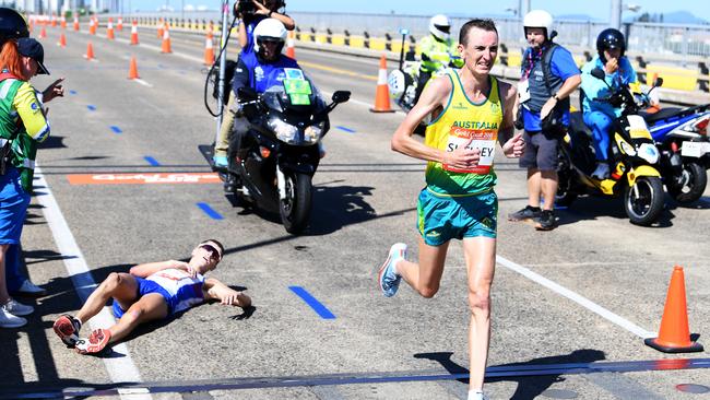 Michael Shelley of Australia runs past collapsed Scotsman Callum Hawkins to win the marathon. Picture: Tracey Nearmy