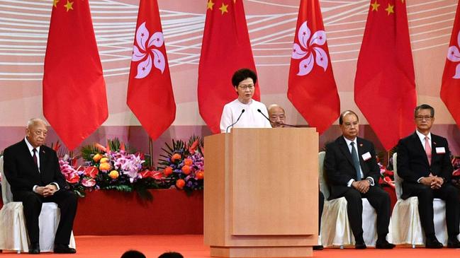 Hong Kong's Chief Executive Carrie Lam (C) speaks to guests following a flag-raising ceremony to mark the 23rd anniversary of Hong Kong's handover from Britain. Picture: AFP.