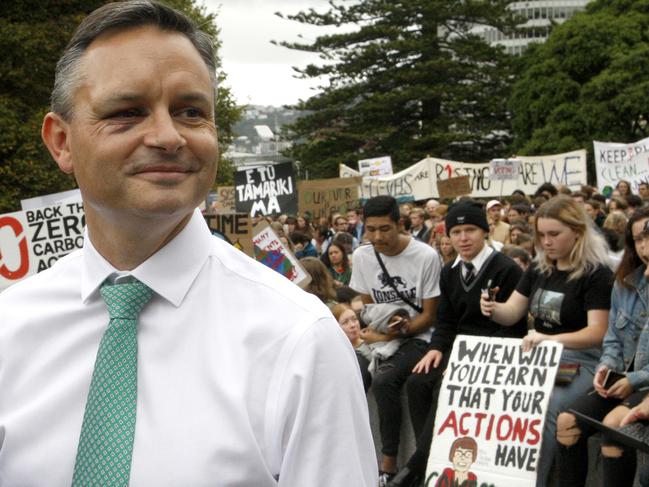 New Zealand's Climate Change Minister James Shaw stands by a student protest on climate change outside parliament in Wellington, New Zealand, Friday, March 15, 2019. Shaw, also co-leader of the Green Party, was walking past Wellington's Botanic Garden just before 8 a.m. Thursday, March 14, 2019, when a man started talking to him before grabbing him and punching him several times. (AP Photo/Nick Perry)