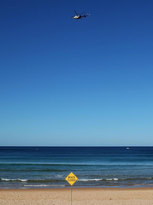 A NSW Police helicopter patrols Manly Beach on Sunday after it was closed because crowds were defying social distancing regulations. Picture: Cameron Spencer/Getty