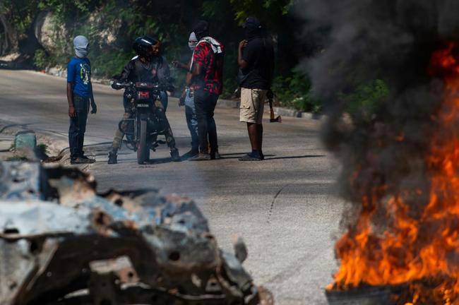 Civilian self-defense groups set alight the bodies of alleged gang members killed in a police operation in Haiti