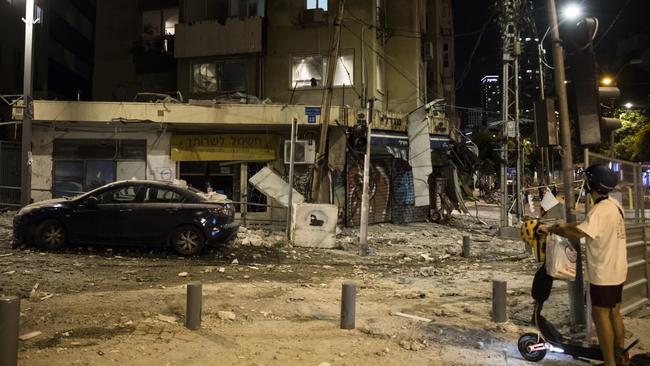 A man passes the scene where a rocket fired from the Gaza Strip hit a building in Tel Aviv, Israel. Picture: Amir Levy/Getty Images