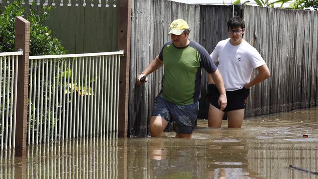 People wade through floodwater in Fairfield. Picture: Tertius Pickard