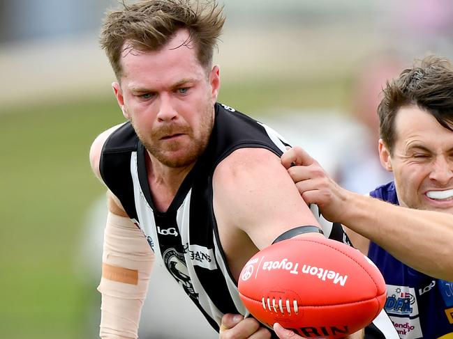 Sean Morris of Wallan is tackled during the round two RDFNL Bendigo Bank Seniors match between Diggers Rest and Wallan at Diggers Rest Recreation Reserve, on April 13,2024, in Diggers Rest, Australia. (Photo by Josh Chadwick)