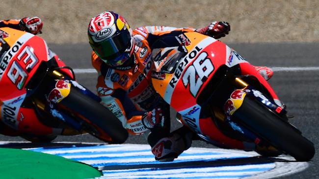 Repsol Honda Team's Spanish rider Dani Pedrosa (R) and his teammate Repsol Honda Team's Spanish rider Marc Marquez take a curve at Jerez de la Frontera race track on May 6, 2017 during the MotoGP fourth free practice session of the Spanish Red Bull Grand Prix. / AFP PHOTO / PIERRE-PHILIPPE MARCOU