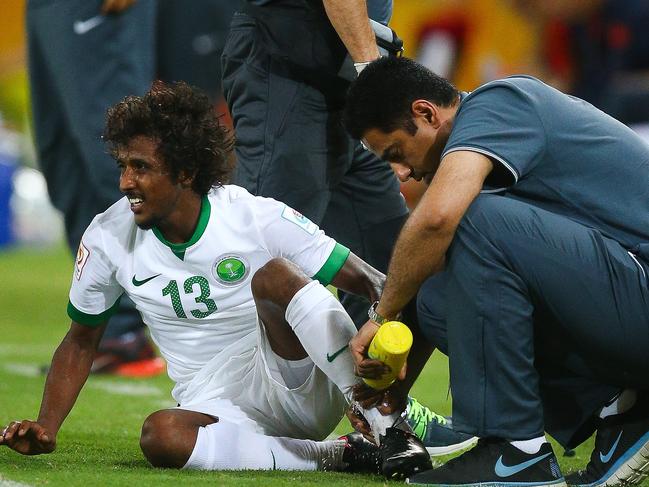 Yasir Alshahrani (L) of Saudi Arabia receives attention during the first round Asian Cup football match between China and Saudi Arabia at the Suncorp Stadium in Brisbane on January 10, 2015. AFP PHOTO / PATRICK HAMILTON ---IMAGE RESTRICTED TO EDITORIAL USE - STRICTLY NO COMMERCIAL USE---