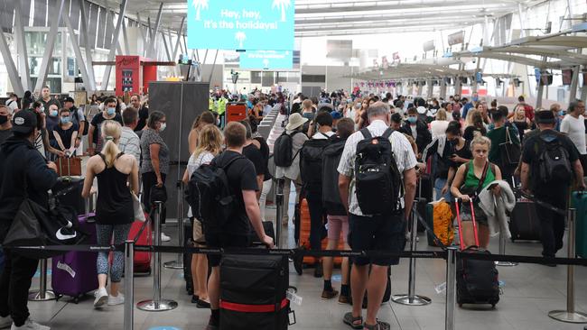 Lines of passengers try to depart Sydney Airport on Friday as travel restrictions tightened.(AAP Image/Dean Lewins)