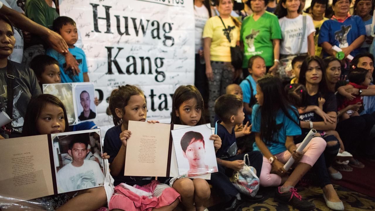 Children hold pictures of their loved ones killed during a mass held for victims of the drug war on February 2, 2017 in Manila. Picture: Dondi Tawatao/Getty Images