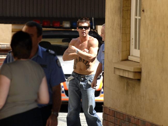 Ben Cousins is led by police after being arrested.