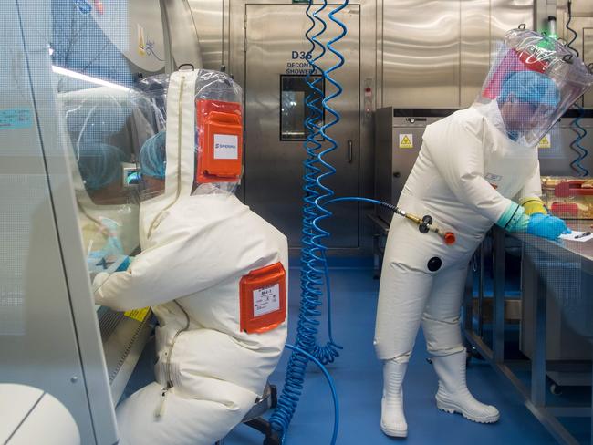 (FILES) This file photo taken on February 23, 2017 shows workers next to a cage with mice (R) inside the P4 laboratory in Wuhan, capital of China's Hubei province. - Chinese state media has offered a rare glimpse of the lab at the heart of coronavirus conspiracy theories, as it seeks to push back against claims the facility was the source of the global pandemic. (Photo by JOHANNES EISELE / AFP)