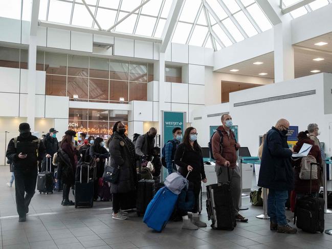 Travellers wait in line to check-in at LaGuardia Airport in New York. On Christmas Eve, airlines, struggling with the Omicron variant have cancelled over 2,000 flights globally. Picture: AFP