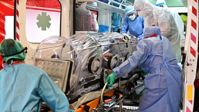 A COVID-19 patient in a bio-containment stretcher is transferred from the Garbagnate Milanaise hospital in Milan, Italy. Picture: AFP