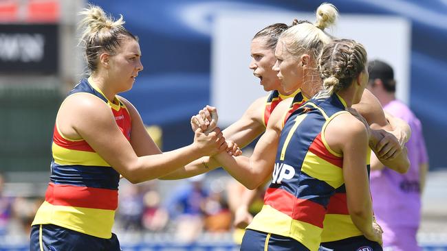 Erin Phillips of the Crows is congratulated by teammates after kicking a goal.