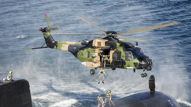 An Australian Submarine conducts personnel transfers with a MRH-90 Taipan helicopter.