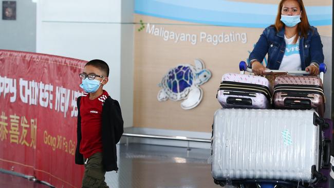 Masked travellers arrive home to Australia. Picture: Brendan Radke