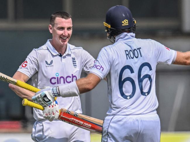 England's Harry Brook (L) celebrates with teammate Joe Root after scoring a double century (200 runs) during the fourth day of the first Test cricket match between Pakistan and England at the Multan Cricket Stadium in Multan on October 10, 2024. (Photo by Aamir QURESHI / AFP)