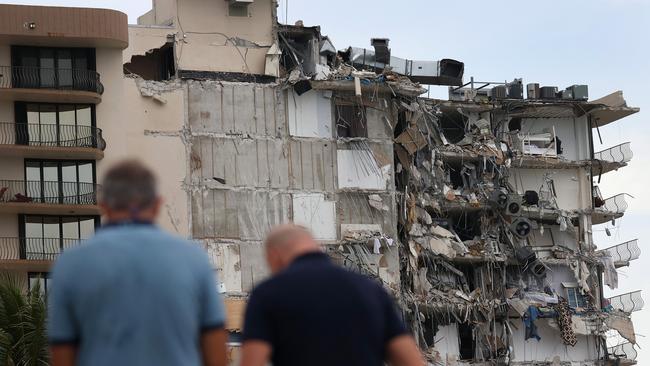 People look at a portion of the 12-storey Champlain Towers South condo building that partially collapsed.