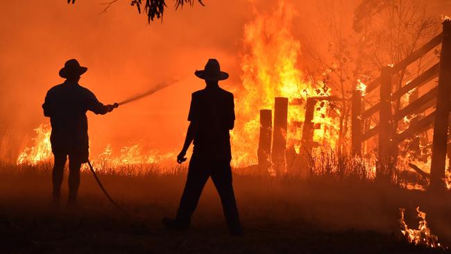 A photo taken on November 12, 2019 shows residents defending a property from a bushfire at Hillsville near Taree,. Picture AFP