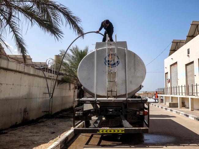 A man fills up a water tanker parked at the Southern Gaza Desalination plant, which stopped working earlier after Israel cut off electricity supply to the Gaza Strip. Picture: AFP