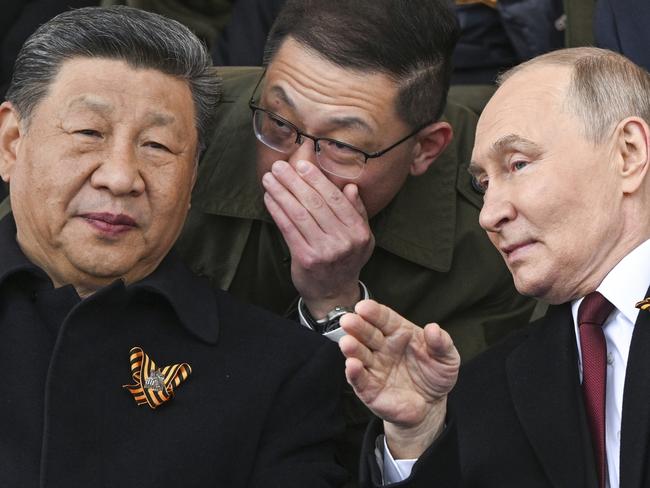 Russian President Vladimir Putin, right, and Chinese President Xi Jinping, left, talk as they watch the Victory Day military parade in Moscow, Russia, Friday, May 9, 2025, during celebrations of the 80th anniversary of the Soviet Union's victory over Nazi Germany during the World War II. (Sergei Bobylev/Photo host agency RIA Novosti via AP)
