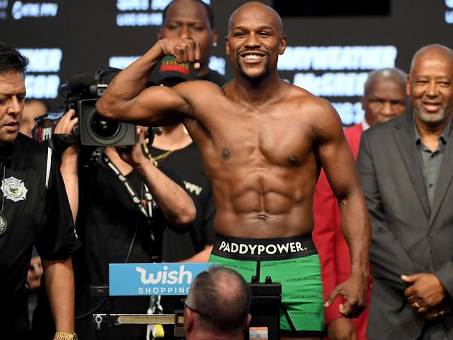 Boxer Floyd Mayweather Jr. poses on the scale during his official weigh-in.