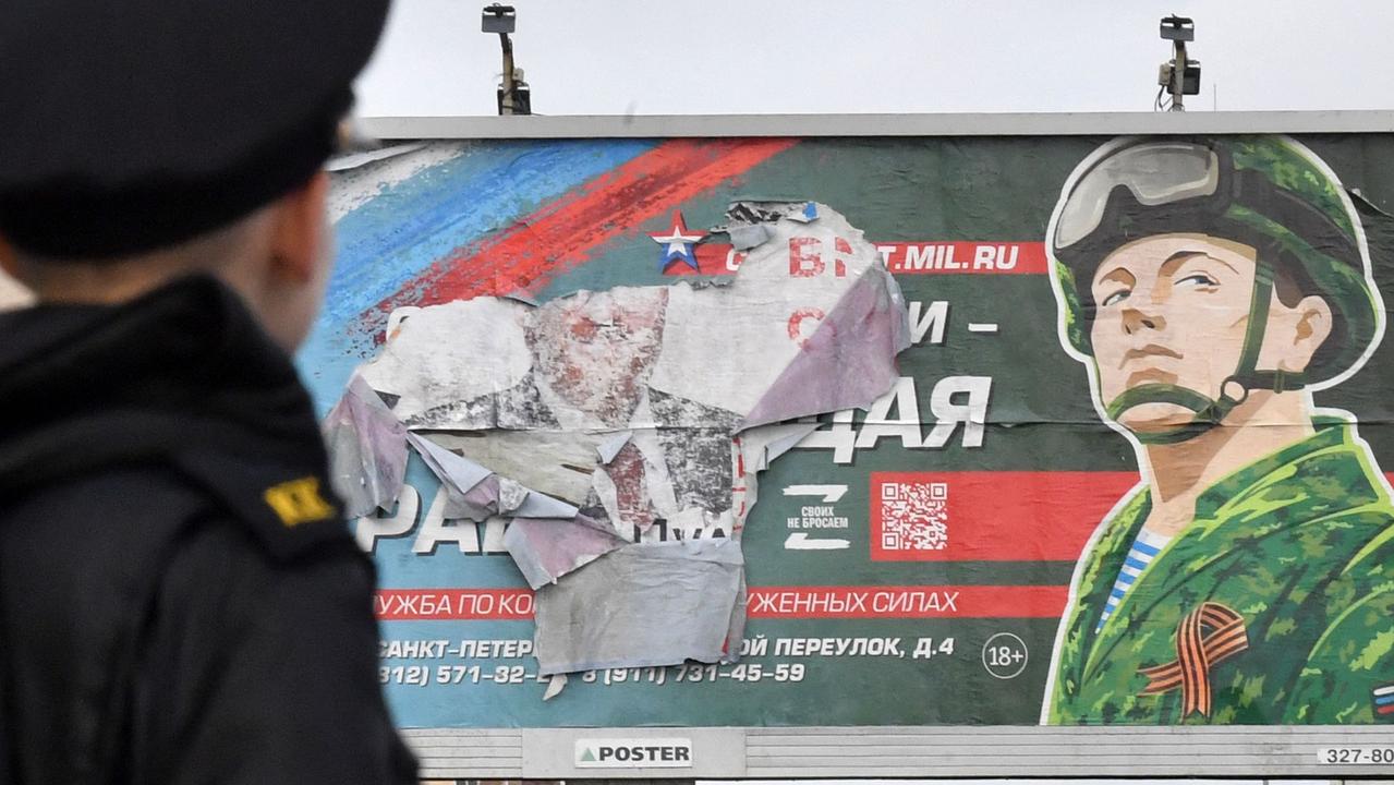 A military cadet stands in front of a billboard promoting contract army service in Saint Petersburg. Picture: Olga Maltseva/ AFP