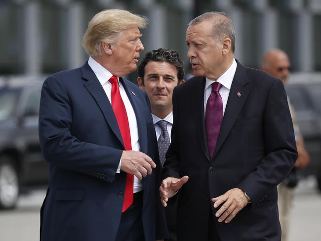 Donald Trump walks and chats with Turkish president Recep Tayyip Erdogan as they arrive together for a ‘family photo’ at the NATO summit. Picture: AP