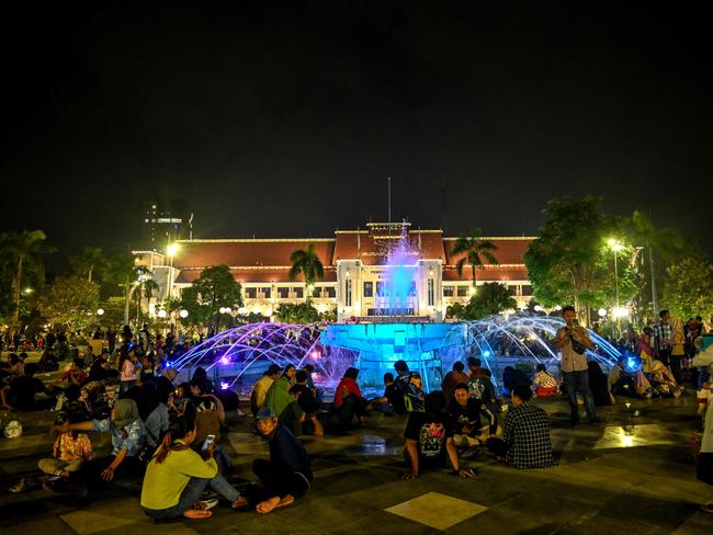 People gather in front of a fountain to celebrate New Year's Eve at city hall in Surabaya on December 31, 2023. Picture: AFP