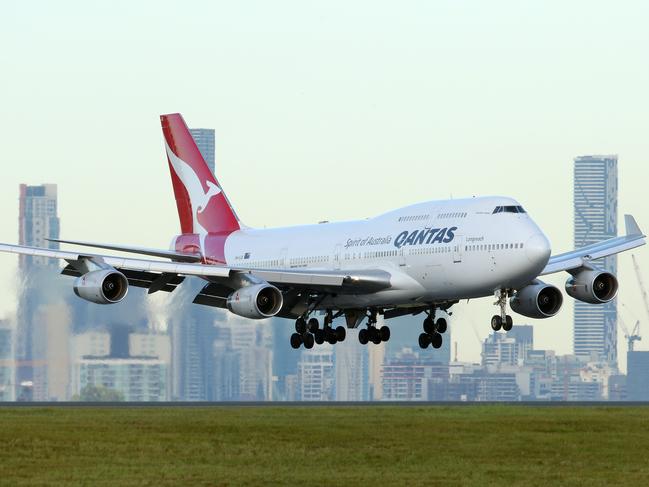 QANTAS plane landing at Brisbane Airport with Brisbane City buildings in background. Photographer: Liam Kidston.