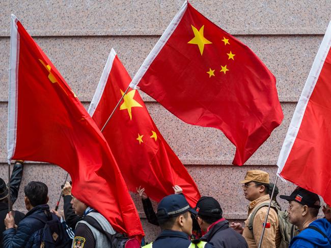 Activists shout slogans while holding China's flag as they gather outside the building that houses the Japanese embassy in Hong Kong on December 13, 2018, to mark 81 years since the 1937 Nanjing massacre. - China says 300,000 people died in a six-week spree of killing, rape and destruction by the Japanese military that began in December 1937 after invading troops seized the city of Nanjing. Some respected foreign academics estimate a lower number of victims, but mainstream scholarship does not question that a massacre took place. (Photo by ANTHONY WALLACE / AFP)