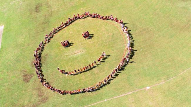 HAPPINESS: Students from Alligator Creek State School make a smiley face on the oval on the National Day of Action against Bullying and Violence. Picture: Photos by Nell