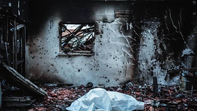 The body of a Palestinian gunman lies covered in a destroyed house after the Israeli army regained control of the Kibbutz Be'eri. Picture: Ilia Yefimovich